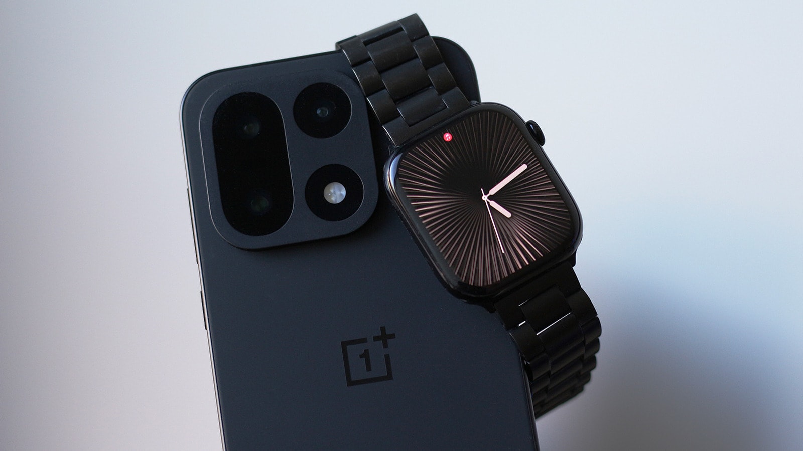 Apple Watch worn on a wrist next to an Android smartphone