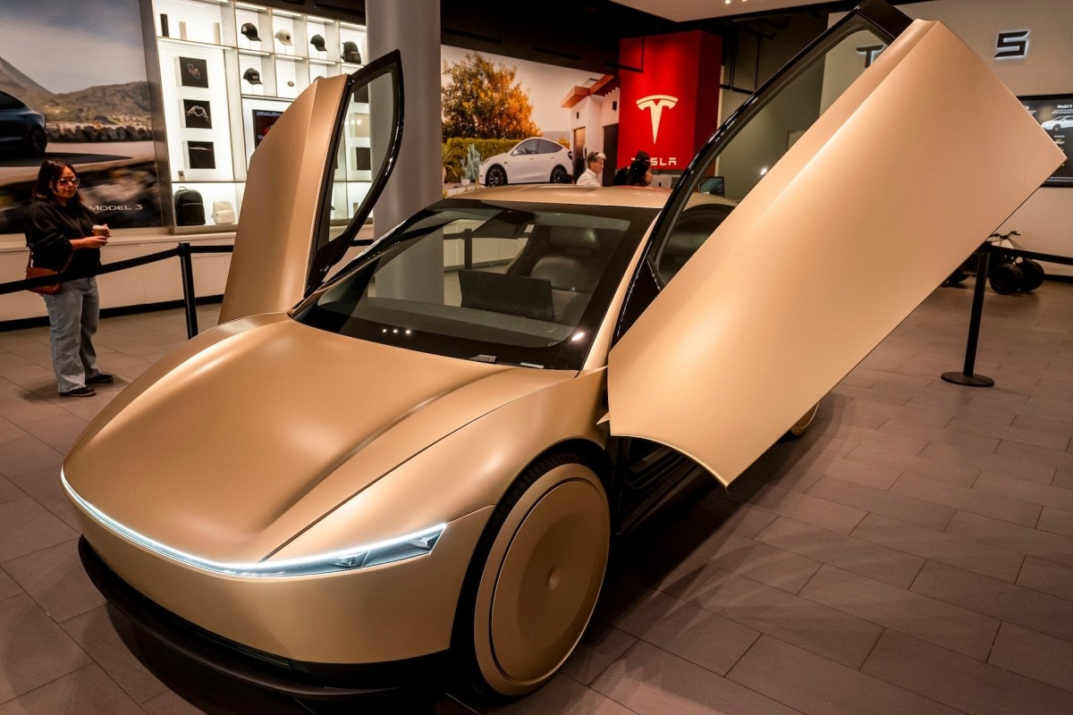 Tesla Cybercab autonomous vehicle alongside the Optimus humanoid robot