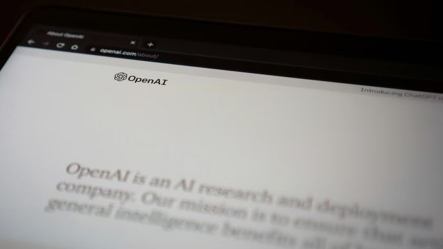 OpenAI logo displayed on a digital screen with legal documents in the foreground.
