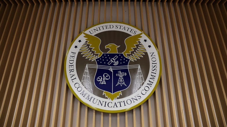 Photo of the FCC insignia displayed on a wall in the agency's briefing room.