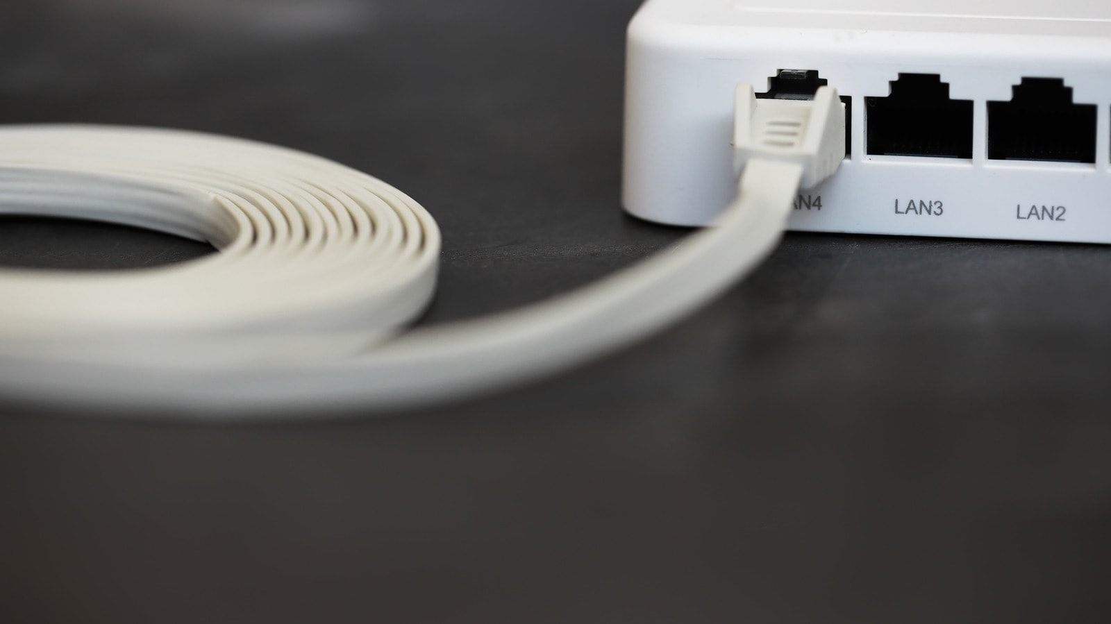 A comparison between a flat Ethernet cable and a traditional round Ethernet cable on a desk.