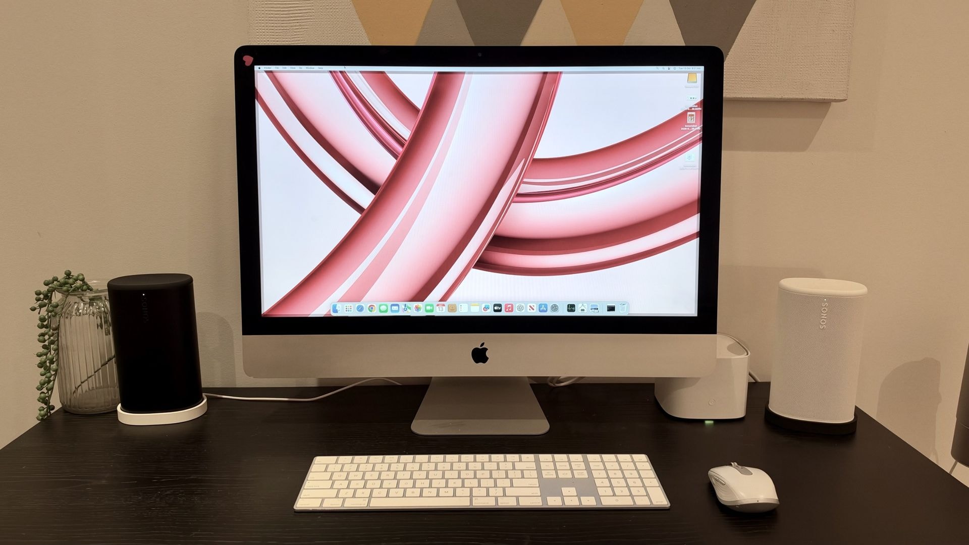 A vintage 27-inch iMac desktop computer on a wooden desk.