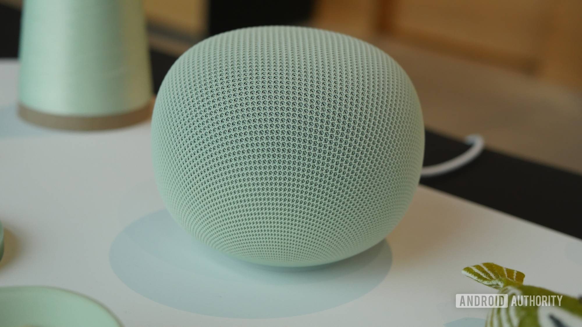 A Google Home smart speaker sitting on a wooden table.