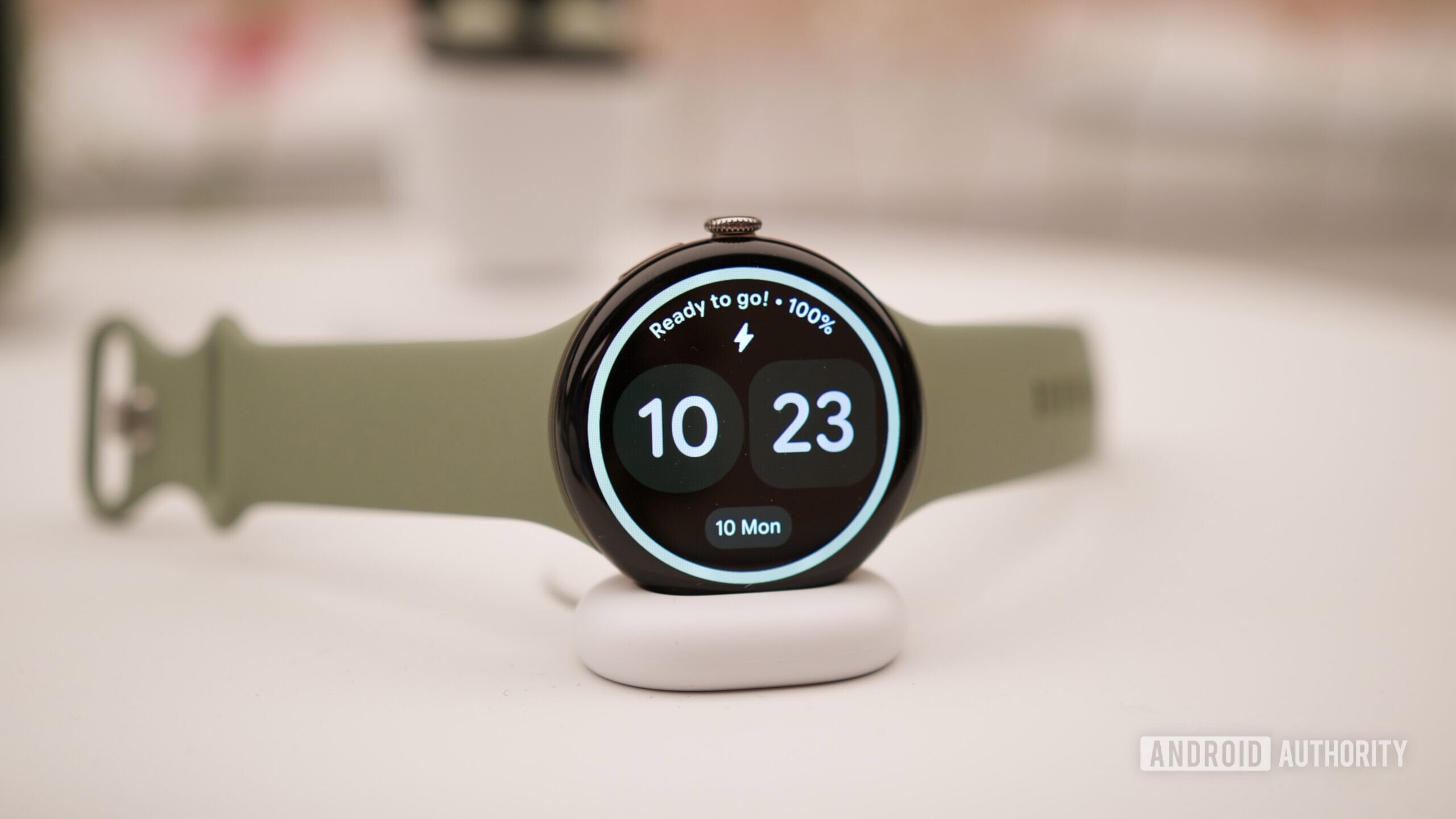 A Google Pixel Watch on a wrist showing a digital display.