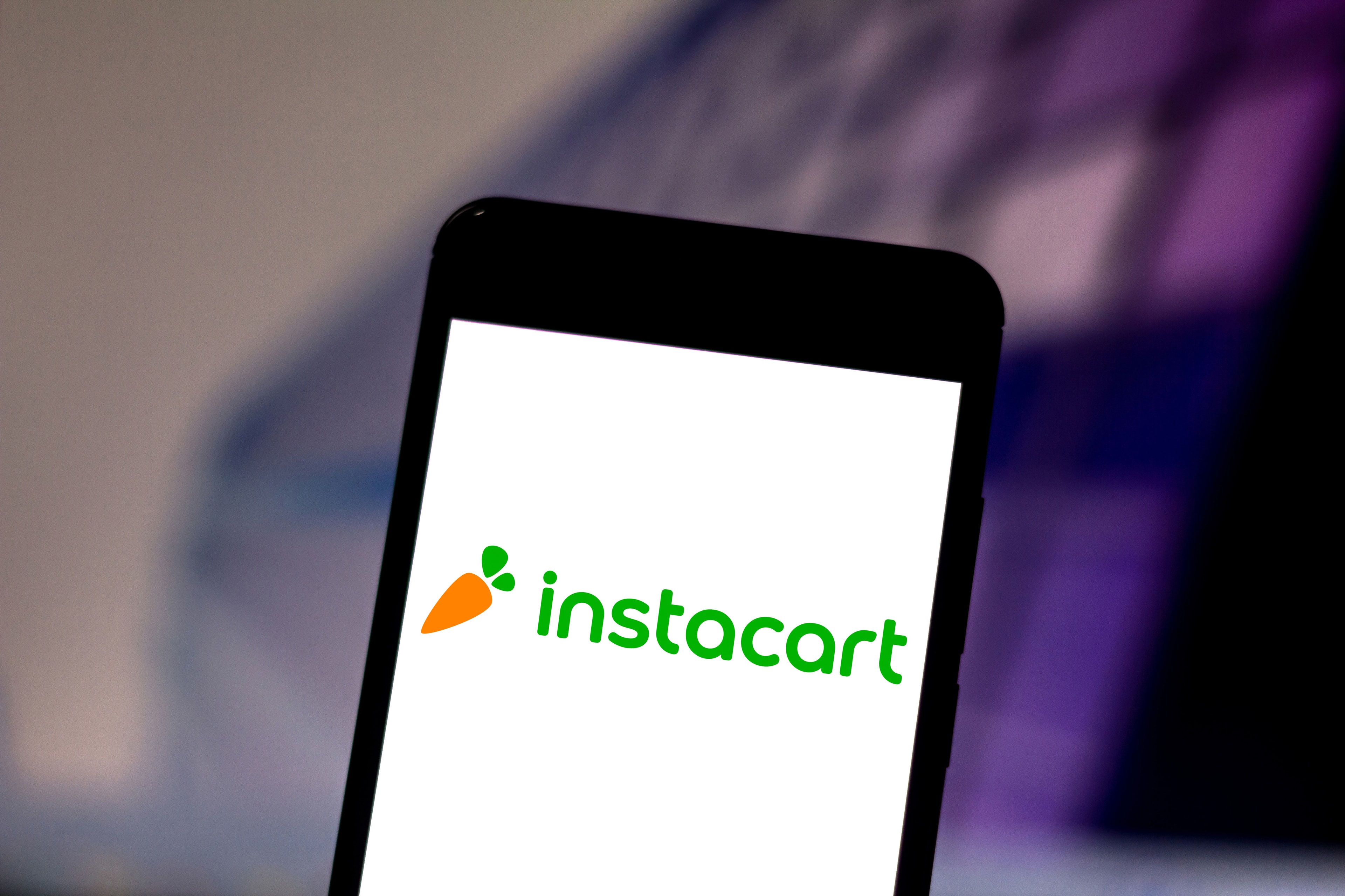 Instacart-ის ლოგო და სმარტფონი მიტანის აპლიკაციით