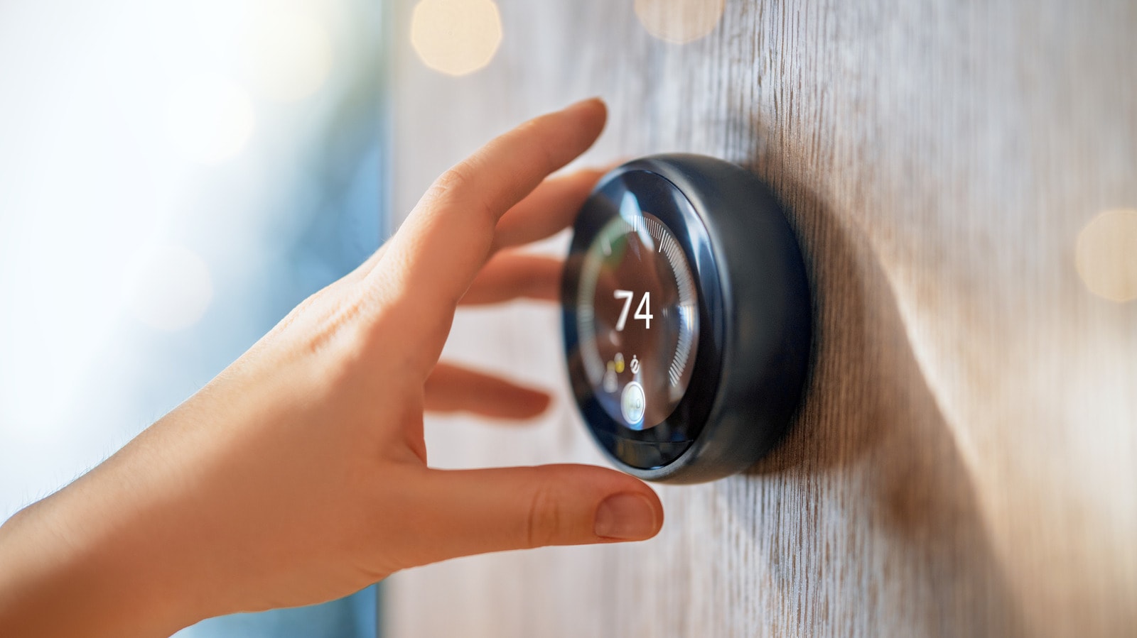 A close-up of a Nest Learning Thermostat mounted on a wall.