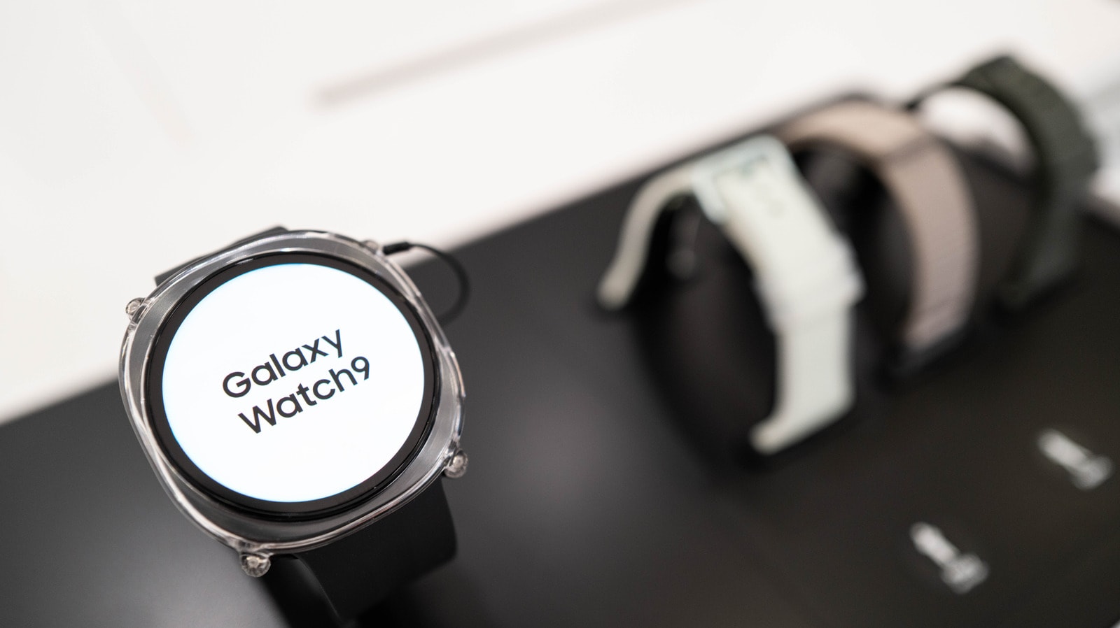 A close-up of a Samsung Galaxy Watch face showing an orange notification dot.