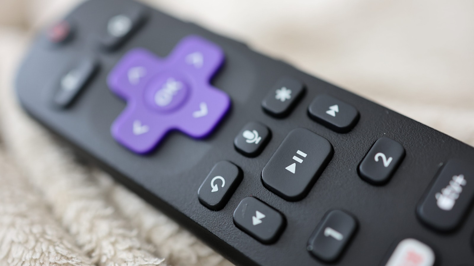 A close-up of a Roku remote control focusing on the star button.