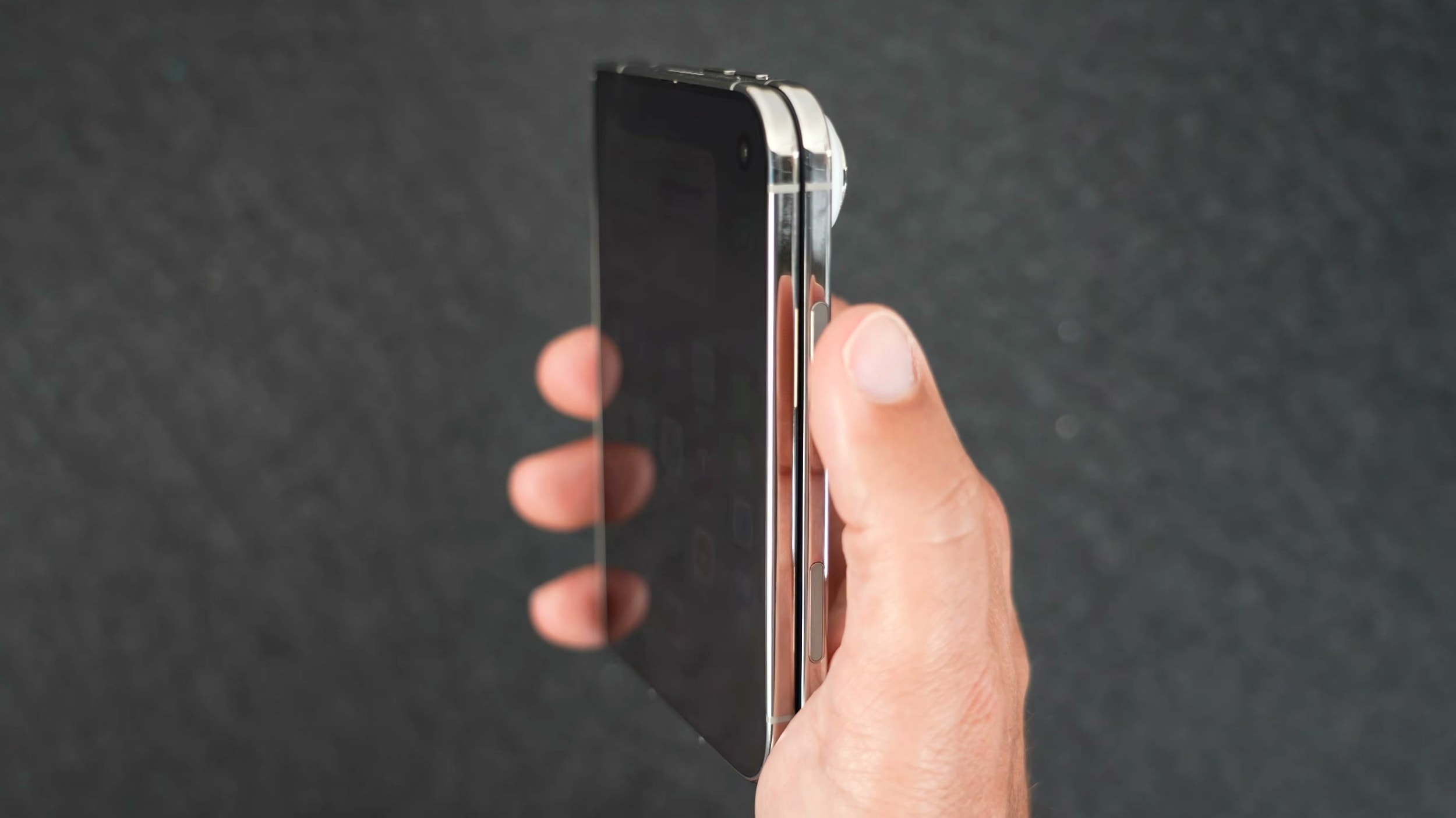 An iPhone Duo held in a hand next to an Apple Watch on a wrist
