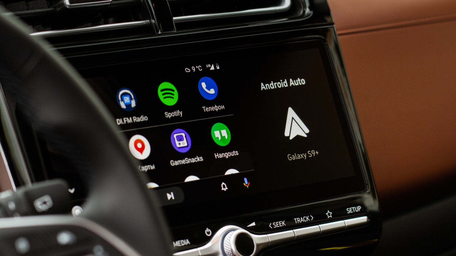A smartphone connected to a car dashboard displaying the Android Auto interface.