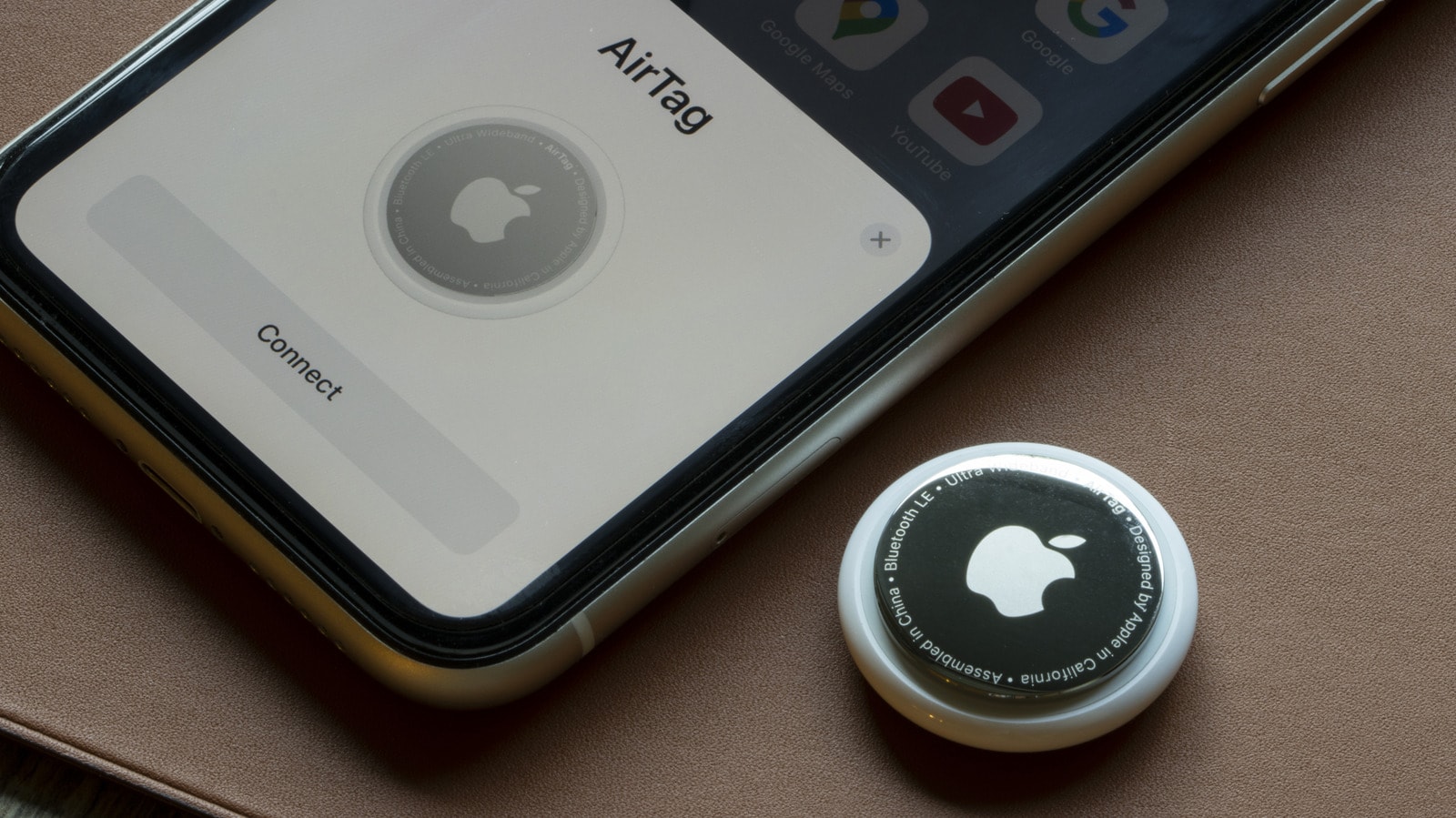 An Apple AirTag attached to a suitcase handle