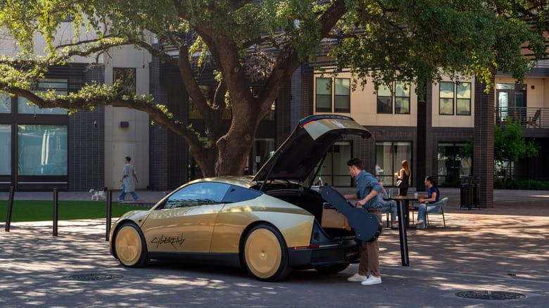 A man loading the trunk of a gold car