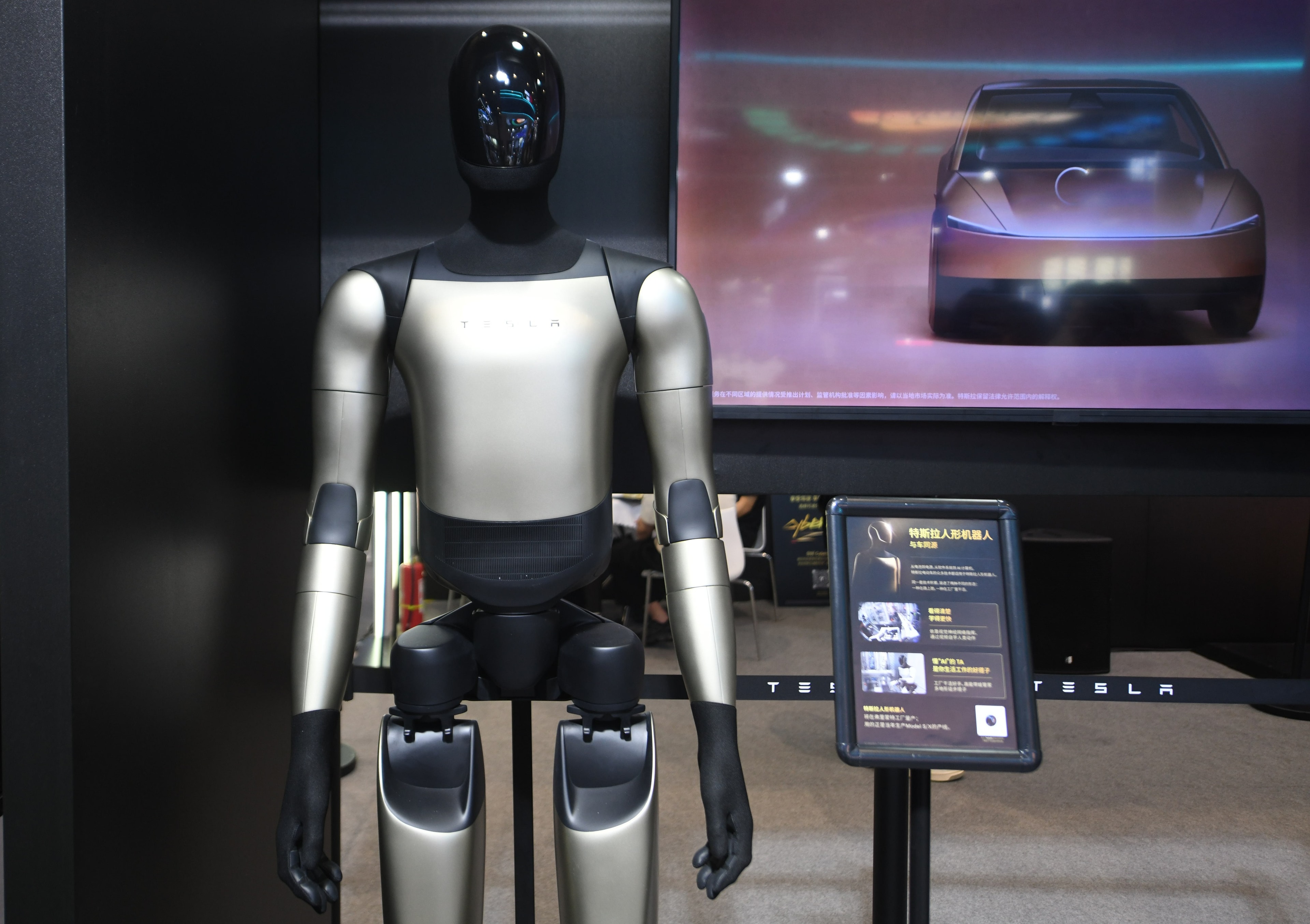 Tesla Optimus humanoid robot standing in a factory setting