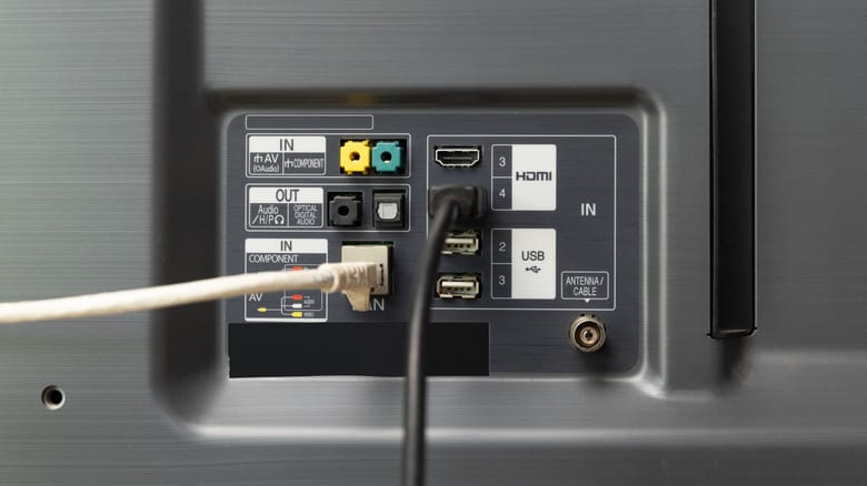 Ethernet and HDMI cables plugged into the back of a TV.