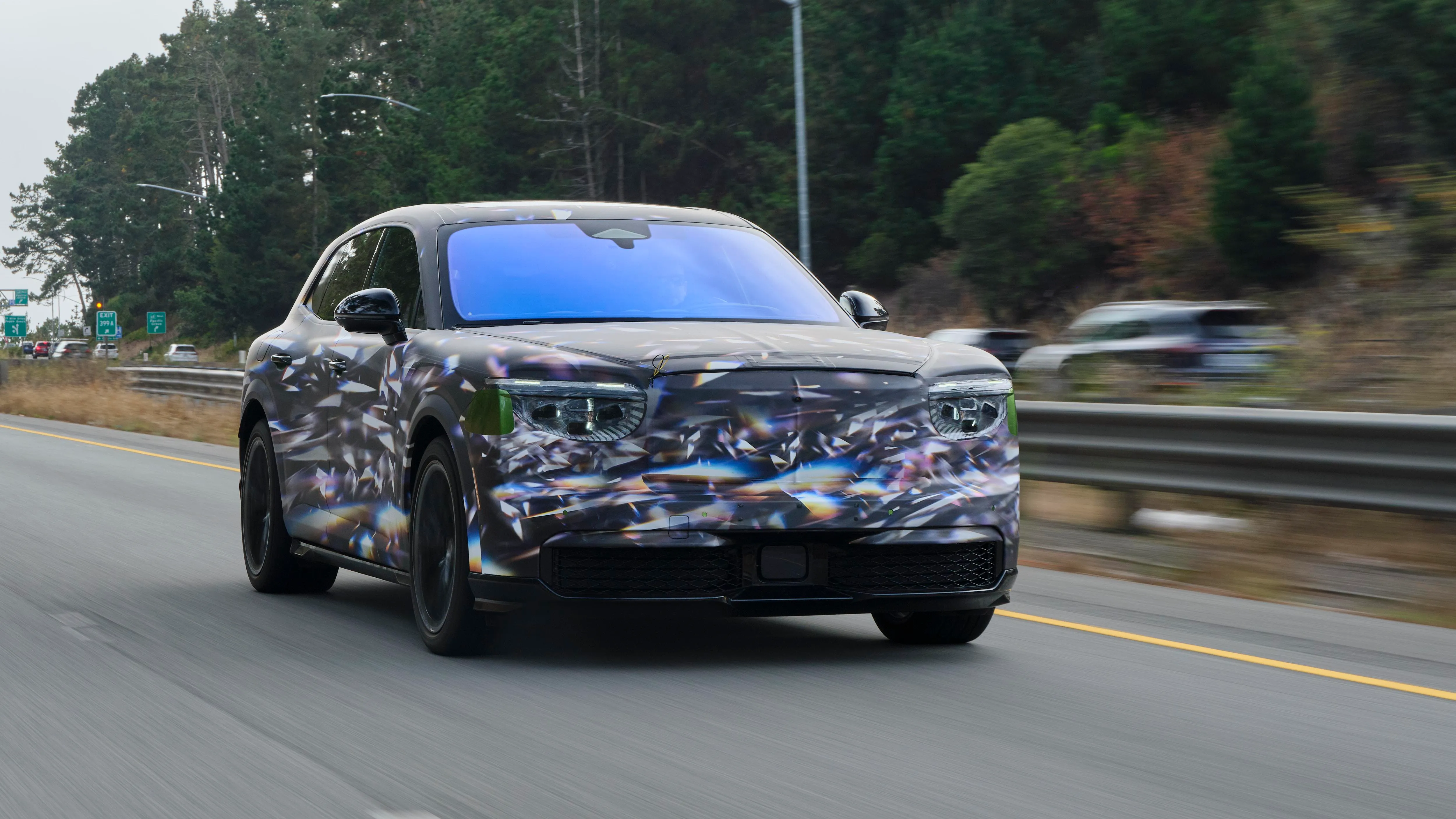 A camouflaged Bentley Torcal electric SUV prototype on a test track